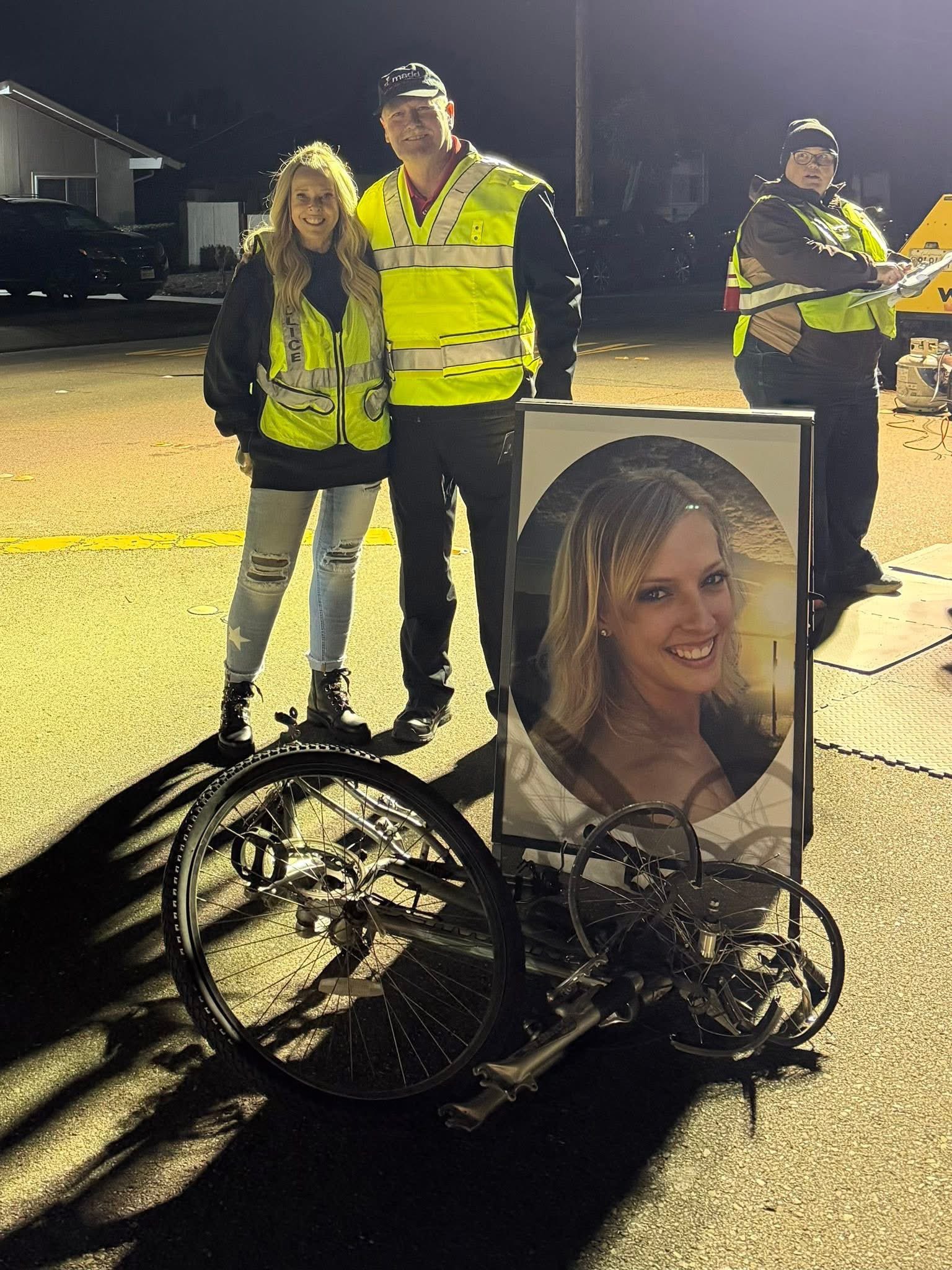 Sandra Burke Chesterman with a Livermore PD officer beside Kristina's photo and bike